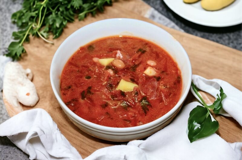 Barszcz ukraiński to zupa przygotowana na wywarze jarzynowym z dodatkiem startych buraków, marchewki, kapusty, ziemniaków i białej fasolki doprawiona na koniec kwaśną śmietaną.