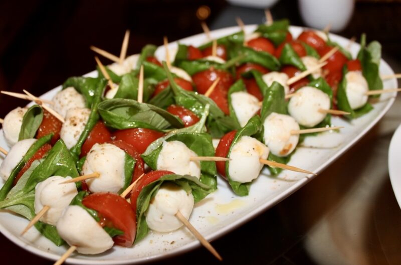 Caprese w poniższym przepisie to moja wersji słynnej włoskiej sałatki z urokliwej wyspy Capri. Przygotowana jest z pomidorków koktajlowych, mozzarelli w kulkach i świeżych liści bazylii nadzianych na wykałaczki. Idealna wersja na domowe party.