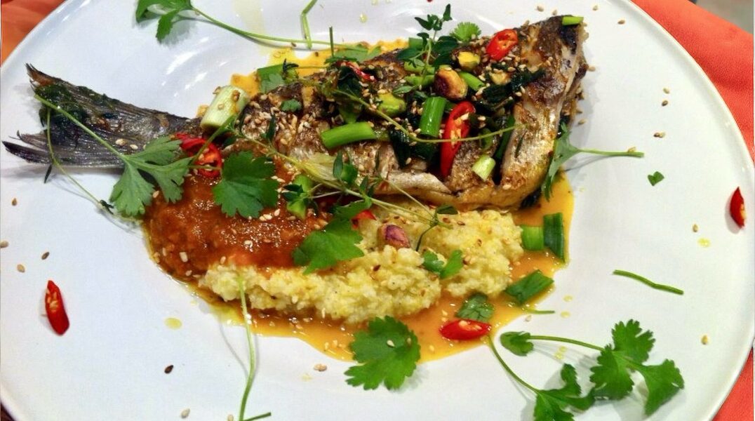 Dorada smażona, a następnie duszona z szafranem w przyprawie harissa z dymką, kiszoną cytryną, rodzynkami i suszonymi morelami.