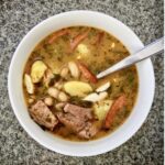 Fasolówka to aromatyczna i sycąca zupa fasolowa. Przygotowuje się ją na bazie aromatycznej wędzonki z dodatkiem mięsa wieprzowego, ziemniaków i pomidorów. Jej smak należy wzbogacić również kiełbasą i suszonym oregano.