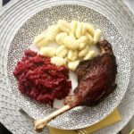 Gęsie nogi przyprawione solą, pieprzem i suszonym majerankiem, a następnie wolno pieczone.