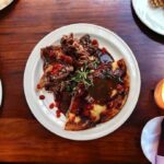 Gęsie udka marynowane w ziołach, a następnie pieczone z majerankiem podane z sosem własnym z dodatkiem octu balsamicznego.