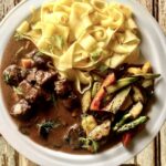 Gulasz z dzika, czyli krojone i marynowane w czerwonym winie mięso z dzika duszone z warzywami z dodatkiem suszonych grzybów i ziół.