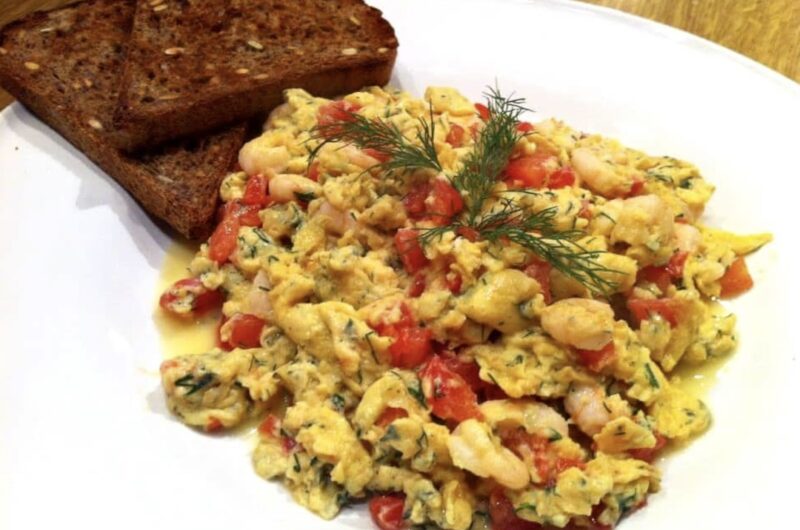 Jajecznica z krewetkami z dodatkiem drobno krojonych pomidorów i świeżego koperku.