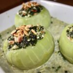 Kalarepa z wydrążonymi środkami faszerowana duszonym szpinakiem, serem feta i orzeszkami piniowymi, a następnie duszona w sosie.