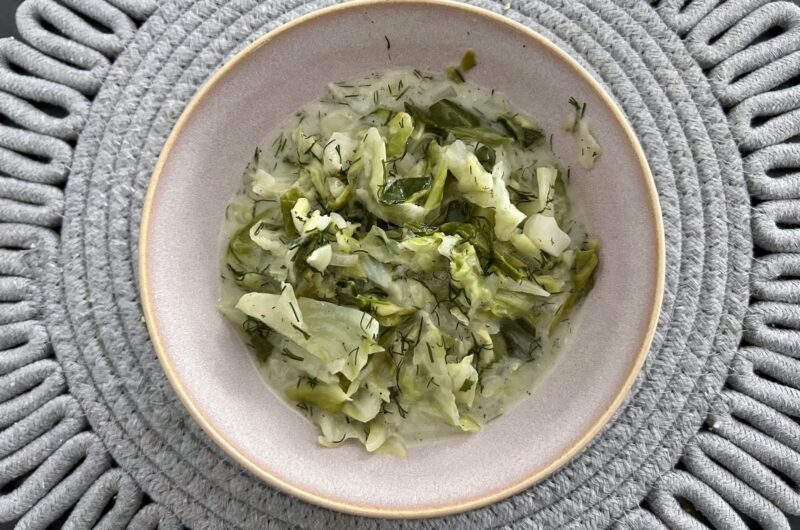 Młoda, drobno siekana i krótko gotowana słodka biała kapusta zasmażana na maśle, z dodatkiem świeżego koperku i kwaśnej śmietany.