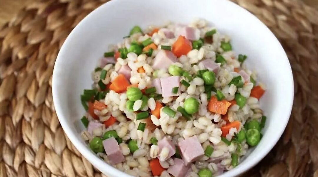 Ugotowana kasza pęczak podana z drobno krojoną szynką gotowaną oraz groszkiem i marchewką.