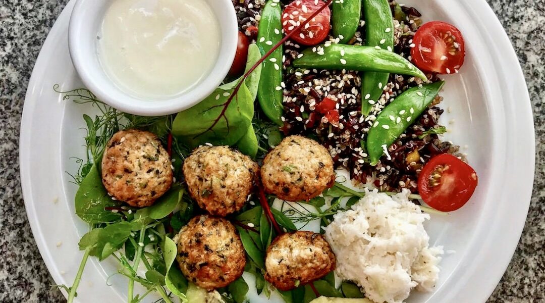 Klopsy z mielonego surowego łososia z dodatkiem świeżych ziół, smażone i podane z sałatką z komosy ryżowej ze zmiksowanymi warzywami.