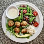 Klopsy z mielonego surowego łososia z dodatkiem świeżych ziół, smażone i podane z sałatką z komosy ryżowej ze zmiksowanymi warzywami.