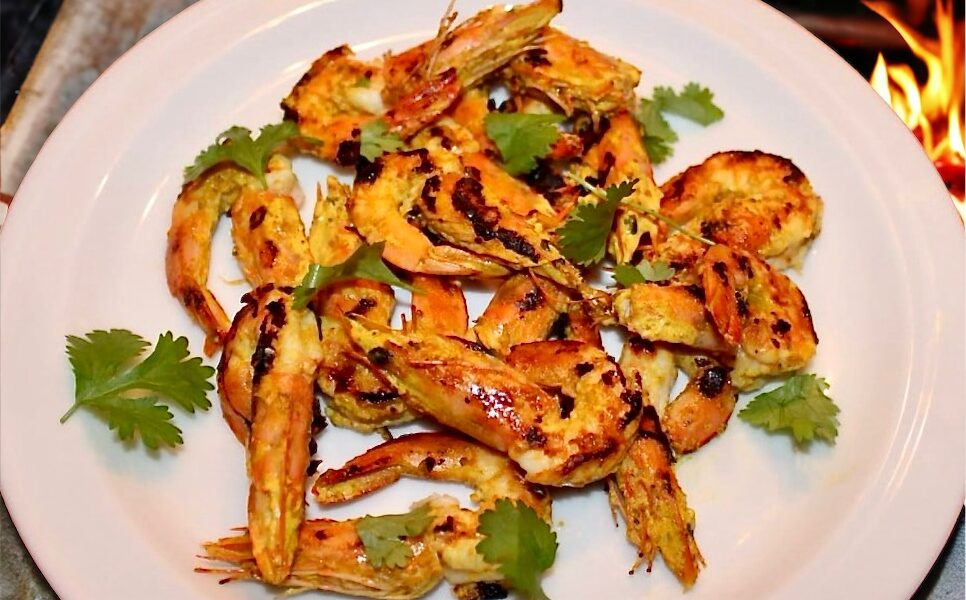 Krewetki marynowane w jogurcie z dodatkiem czosnku, chili, kolendry i kurkumy, a następnie grillowane na ruszcie.