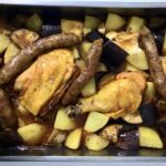 Kurczak z piekarnika z bakłażanem to kompletny posiłek składający się z pieczonych udek z kurczaka, kiełbasek wieprzowych oraz ziemniaków, bakłażana i główki czosnku.