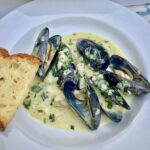 Małże po marynarsku to małże krótko smażone z szalotką i czosnkiem, a następnie duszone w białym winie i finalnie doprawione słodką śmietanką.