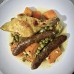 Obiad na niedzielę to mięso marynowane w oliwie z oregano, musztardzie i soku z cytryny, a następnie pieczone razem z kiełbaskami i warzywami.