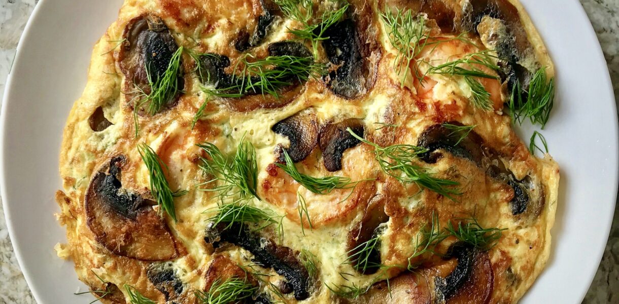 Omlet z krewetkami dodatkiem smażonych pieczarek i kawałków sera feta.