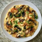 Omlet z krewetkami dodatkiem smażonych pieczarek i kawałków sera feta.