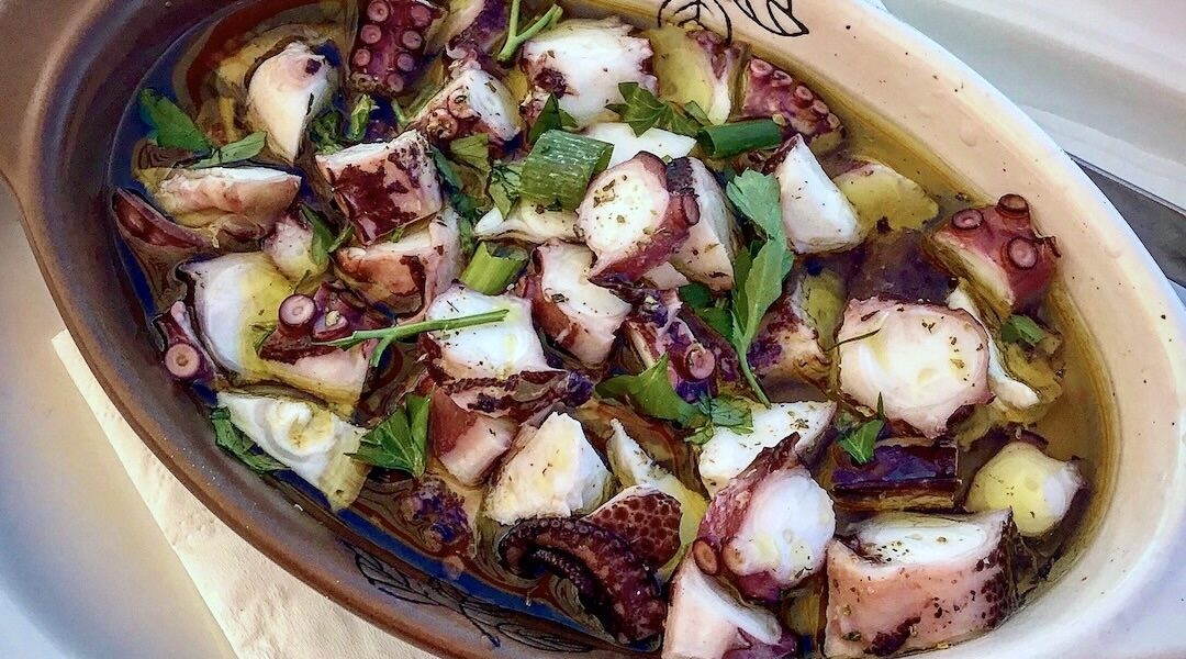 Ośmiornica gotowana w sosie własnym, a następnie krojona i zalana sosem winegret z dodatkiem kawałków świeżej papryki i natki pietruszki.