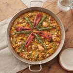 Paella Valenciana to tradycyjna potrawa hiszpańska z mięsa i warzyw z dodatkiem ryżu z szafranem i mieloną papryką.