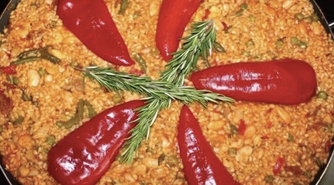 Paella Valenciana to tradycyjna potrawa hiszpańska z mięsa i warzyw z dodatkiem ryżu z szafranem i mieloną papryką.