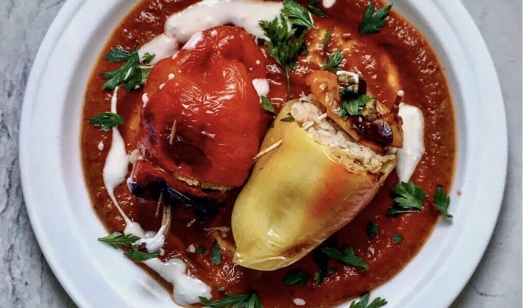 Papryka faszerowana kurczakiem to przekrojone na połowę papryki wypełnione farszem z kurczaka i ryżu, a następnie zapiekane i podane na sosie pomidorowym.