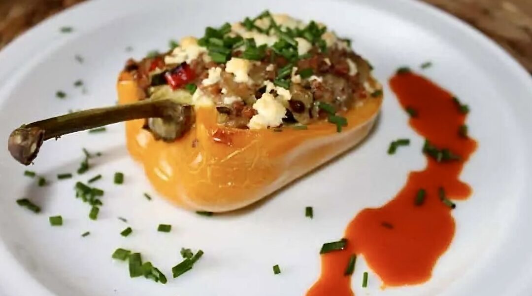 Przekrojona na połowę papryka faszerowana warzywami i kaszą z dodatkiem, a następnie zapiekana.