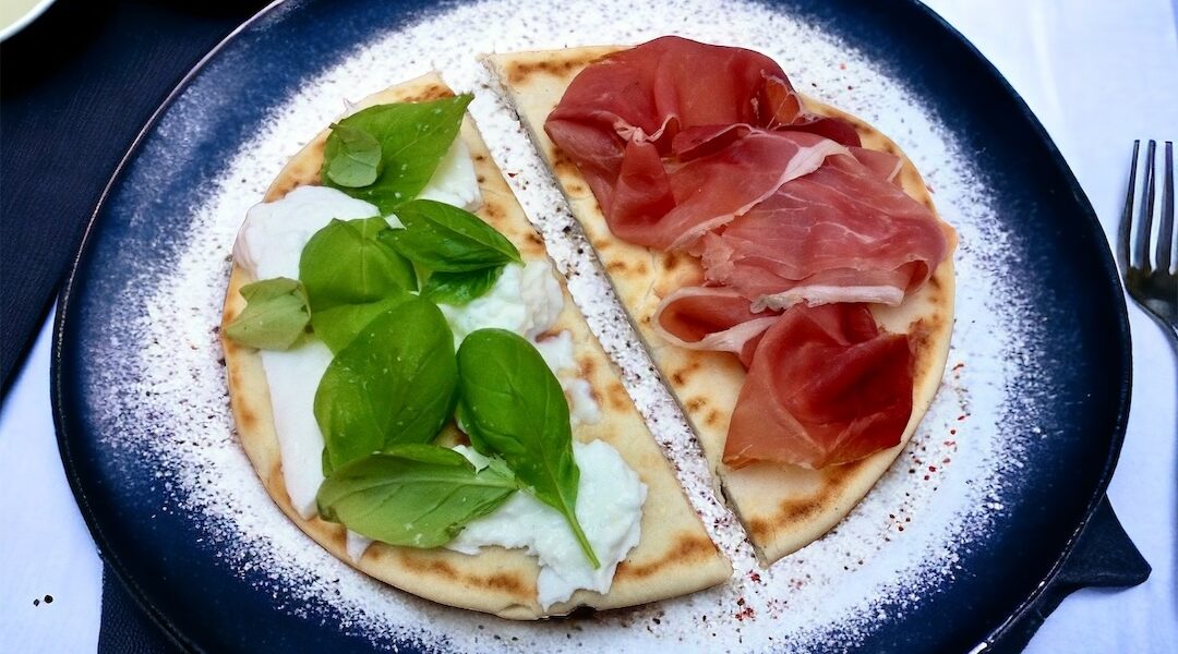 Piadina romagnola to nieduży włoski placek przyrządzany z mąki pszennej i smalcu. Po krótkim smażeniu piadinę wypełnia się ulubionymi składnikami i podgrzewa zajadając go jako sycącą przekąskę.
