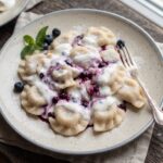 Pierogi wypełnione leśnymi borówkami z dodatkiem cukru gotowane i polane kwaśną śmietaną.