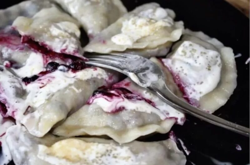 Pierogi wypełnione leśnymi borówkami z dodatkiem cukru gotowane i polane kwaśną śmietaną.
