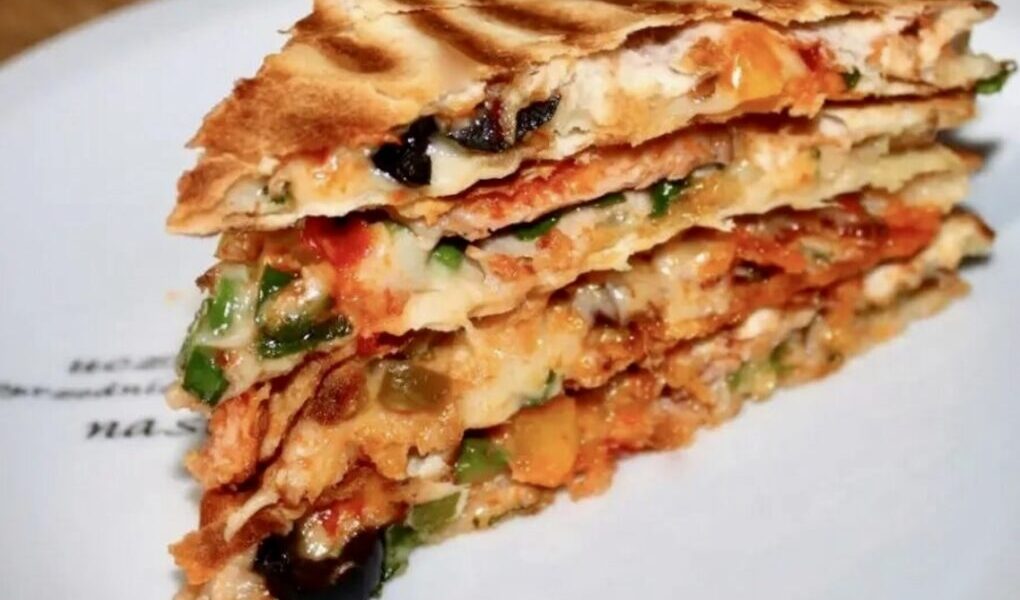 Quesadilla z pieczarkami to tortilla obłożona wędliną, startym serem, papryką i szparagami, następnie przykryta drugą tortillą i podgrzana na patelni.