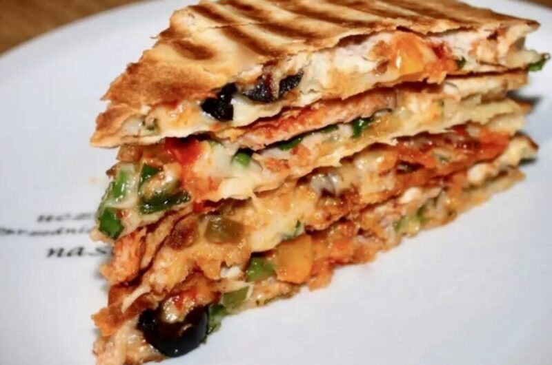 Quesadilla z pieczarkami to tortilla obłożona wędliną, startym serem, papryką i szparagami, następnie przykryta drugą tortillą i podgrzana na patelni.
