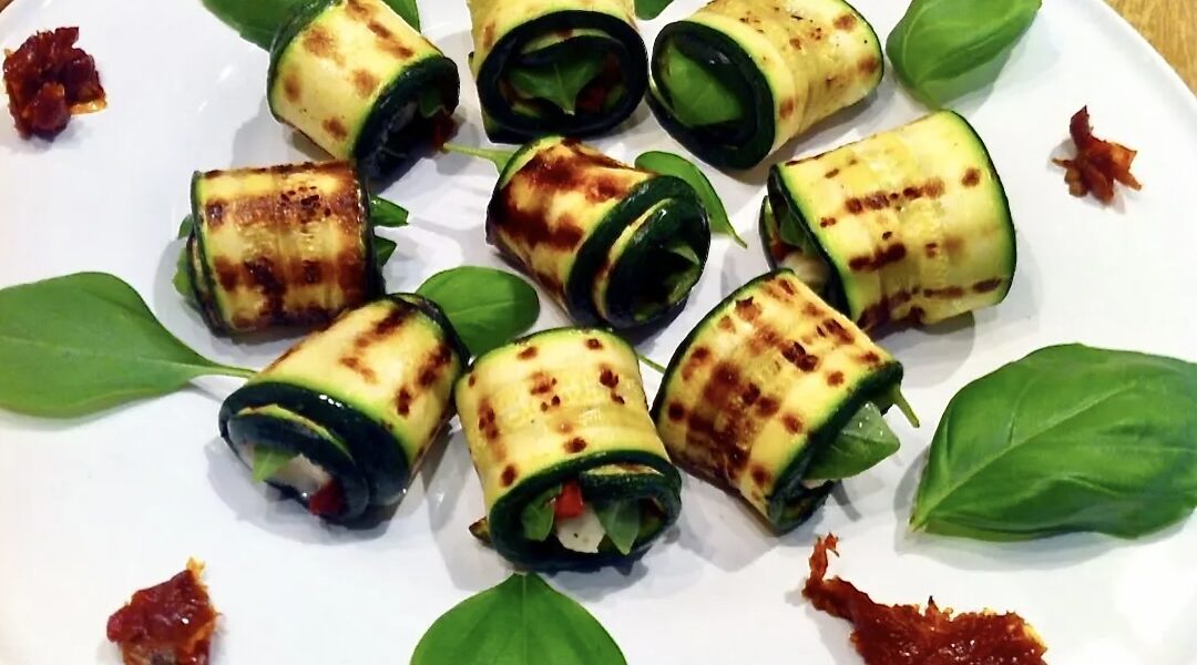 Roladki z cukinii przygotowujemy z plastrów świeżej cukinii. Cukinia pokrojona wzdłuż na plasterki najpierw powinna zostać grillowana. Później posmarowaną oliwą cukinię wypełniamy kawałkiem sera gorgonzola i suszonym pomidorem i zwijamy w roladkę.