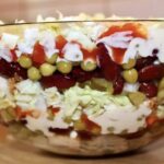 Sałatka warstwowa z kurczakiem przyrządzona została ze smażonej w przyprawach piersi z kurczaka, która po pokrojeniu ułożona została naprzemiennie z groszkiem, czerwoną fasolką, siekanymi ogórkami kiszonymi, a także kapustą pekińską. Całą sałatkę spoił majonez.