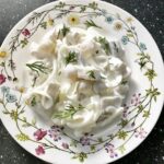 Śledzie w śmietanie czyli małe kawałki śledzia matiasa zmieszane z kwaśną śmietaną z dodatkiem cebuli i białych winogron.