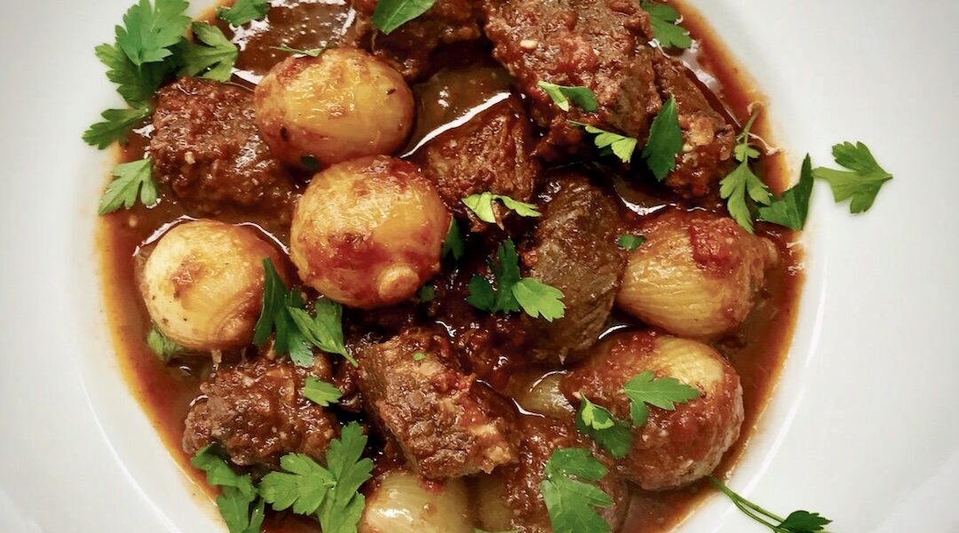 Stifado, czyli grecki gulasz duszony z kawałków wołowiny i dużej ilości cebulek perłowych w sosie pomidorowym oraz aromatycznych przypraw.