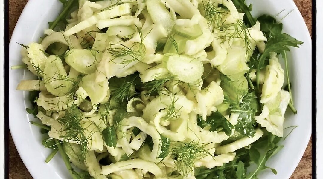 Surówka z krojonego fenkuła z dodatkiem liści czosnku niedźwiedziego skropiona sosem winegret z musztardą.