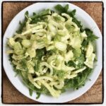 Surówka z krojonego fenkuła z dodatkiem liści czosnku niedźwiedziego skropiona sosem winegret z musztardą.