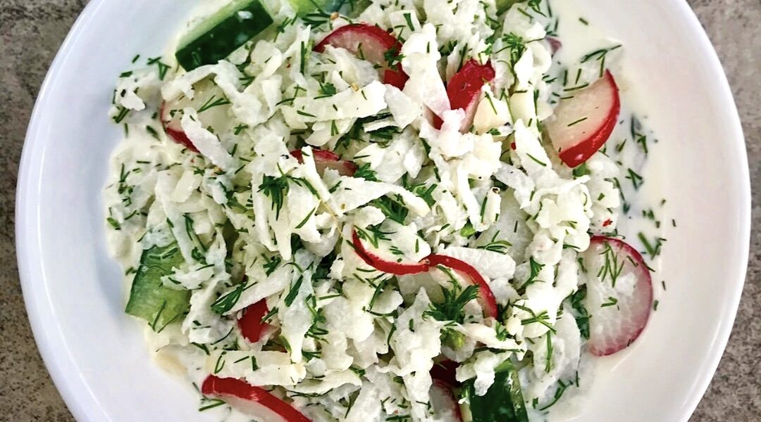 Surówka z dwóch rodzajów rzodkiewki z dodatkiem świeżego ogórka doprawiona kwaśną śmietaną i świeżym koperkiem.