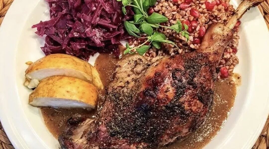 Udo z gęsi pieczone, doprawione suszonym majerankiem upieczone razem z jabłkami podane w sosem własnym z przetartymi pieczonymi jabłkami.