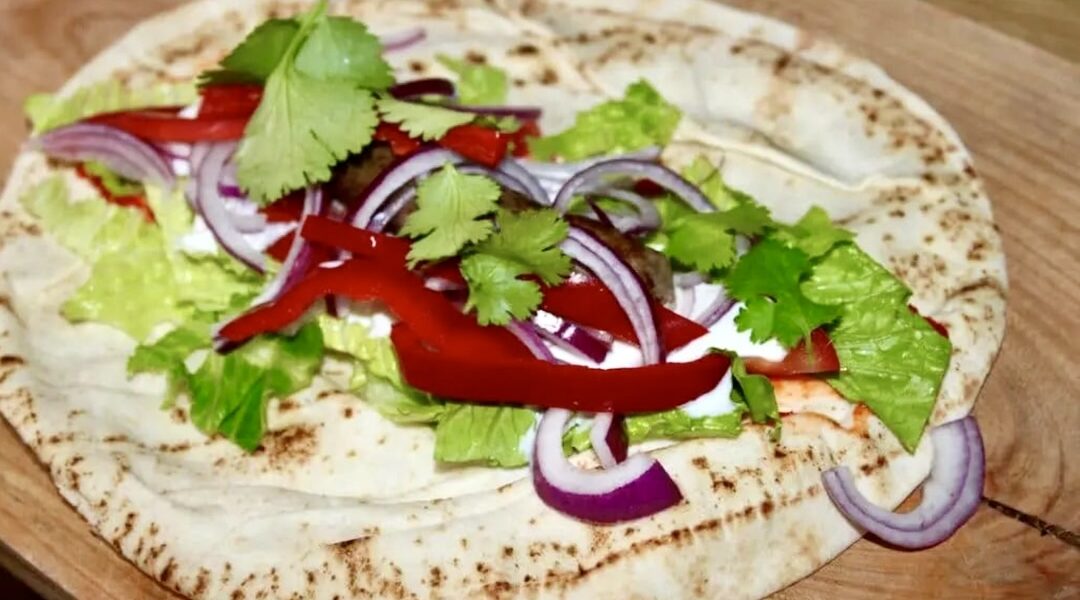 Wrapy z kiełbaską to chlebki arabskie wypełnione warzywami i smażoną jagnięcą kiełbaską merguez oraz z dodatkiem świeżej kolendry i jogurtu.