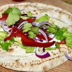 Wrapy z kiełbaską to chlebki arabskie wypełnione warzywami i smażoną jagnięcą kiełbaską merguez oraz z dodatkiem świeżej kolendry i jogurtu.