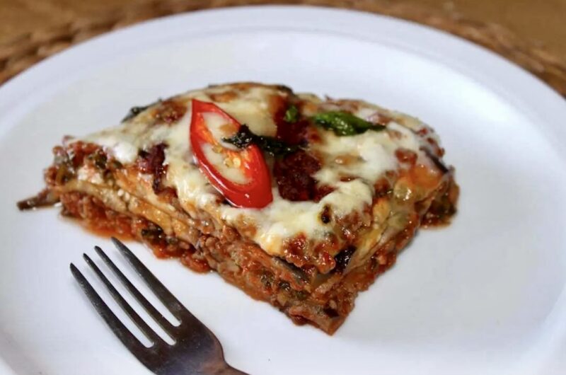 Zapiekanka z bakłażanem przekładanym aromatycznym mięsem mielonym w sosie pomidorowym od góry obłożona serem taleggio i ostrym chilli.