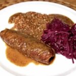 Zrazy wołowe z sosem grzybowym przygotowałem z udźca wołowego. Plastry wołowiny posmarować należy musztardą, obłożyć plastrami szynki dojrzewającej i kawałkami ogórka kiszonego, a następnie zawinąć w rolady i dusić wolno w sosie z grzybami do miękkości zrazów.