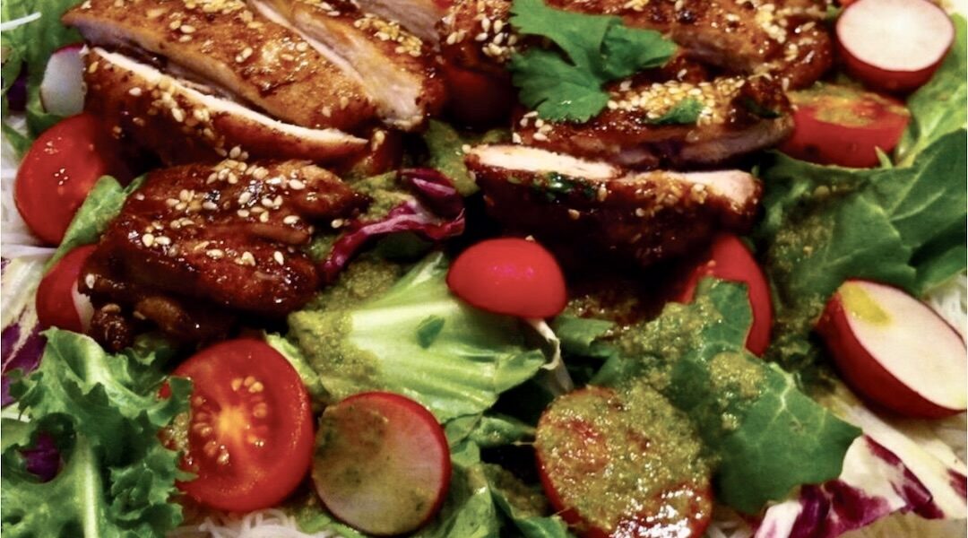 Azjatycka sałatka z orientalnie przyprawionym smażonym kurczakiem podanym na makaronie ryżowym z dodatkiem sałat i rzodkiewek oraz aromatycznego dipu.