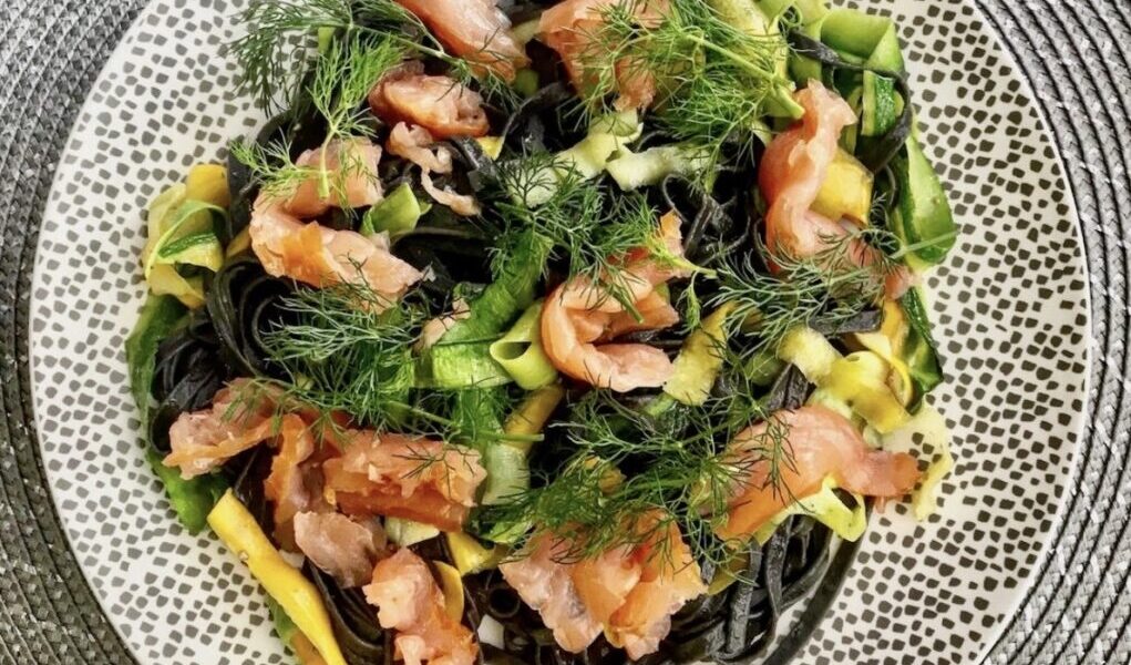 Czarny makaron z łososiem, czyli makaron zabarwiony na czarno atramentem sepii połączony z tagliatelle warzywnym przygotowanym z cukinii oraz z dodatkiem wędzonego łososia.