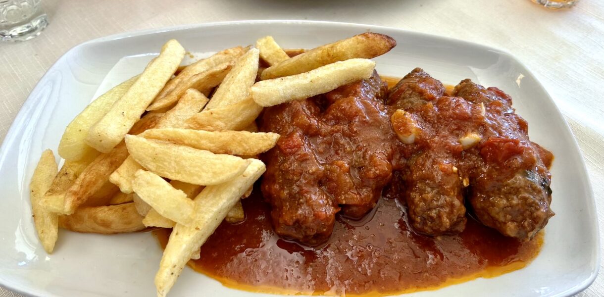 Klopsy mielone przyrządzone z wołowo-wieprzowego mięsa mielonego z dodatkiem bułki moczonej w winie oraz kminu rzymskiego, cynamonu i czosnku podane w sosie pomidorowym