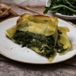 Płaty makaronu lasagne ze szpinakiem przekładanym fetą, a następnie zapiekane na chrupiąco.