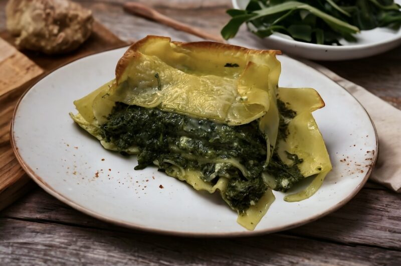 Płaty makaronu lasagne ze szpinakiem przekładanym fetą, a następnie zapiekane na chrupiąco.