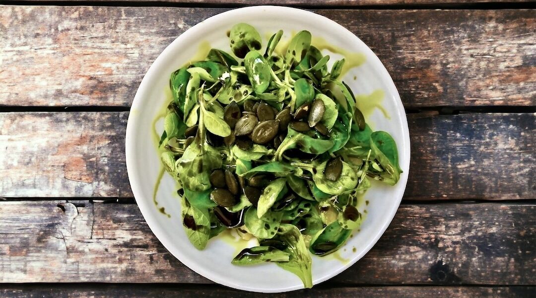 Sałatka z gotowanymi i pokrojonymi w cienkie plasterki ziemniakami doprawiona na kwaśno i podana ze świeżą roszponką.