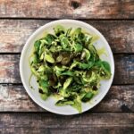 Sałatka z gotowanymi i pokrojonymi w cienkie plasterki ziemniakami doprawiona na kwaśno i podana ze świeżą roszponką.