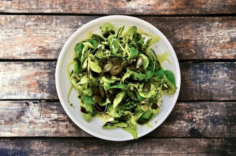 Sałatka z gotowanymi i pokrojonymi w cienkie plasterki ziemniakami doprawiona na kwaśno i podana ze świeżą roszponką.