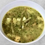 Zupa jarzynowa na bazie bulionu warzywnego z dodatkiem fasolki szparagowej, bobu i cukinii doprawiona domowym pesto bazyliowym.